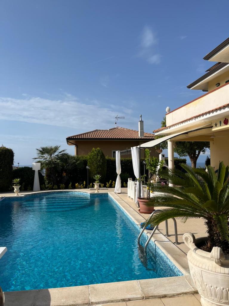 une piscine devant un immeuble dans l'établissement Villa Solemar, à Briatico