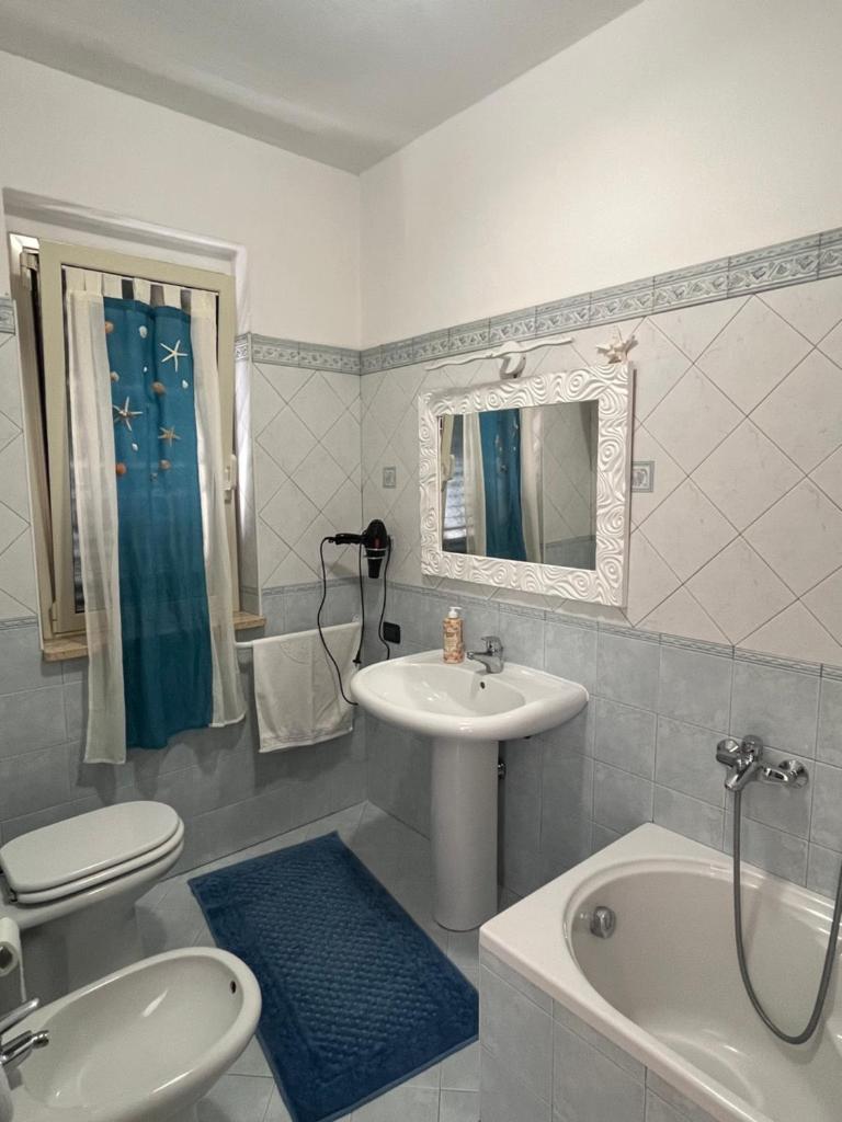 une salle de bain avec un lavabo, des toilettes et une baignoire dans l'établissement Villa Solemar, à Briatico