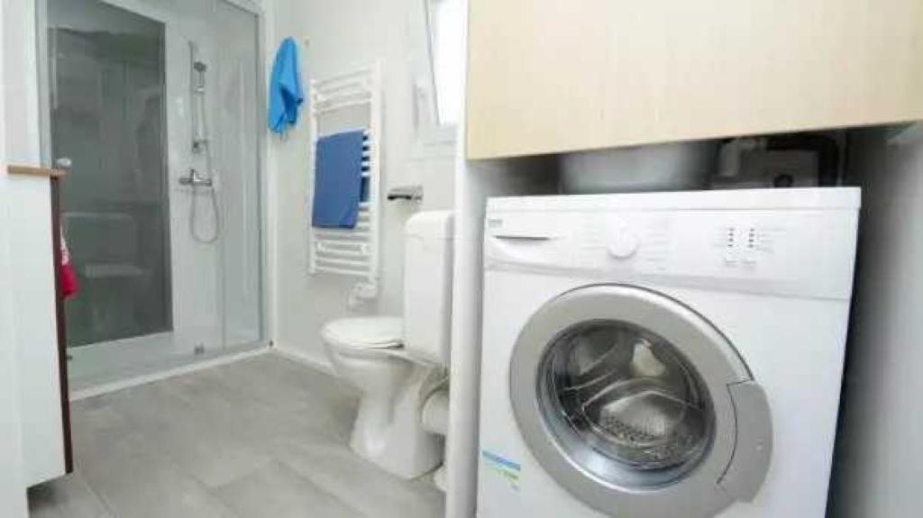 une salle de bain avec machine à laver et toilettes dans l'établissement Camping 4 étoiles - Parc aquatique - eece0c, à Grimaud