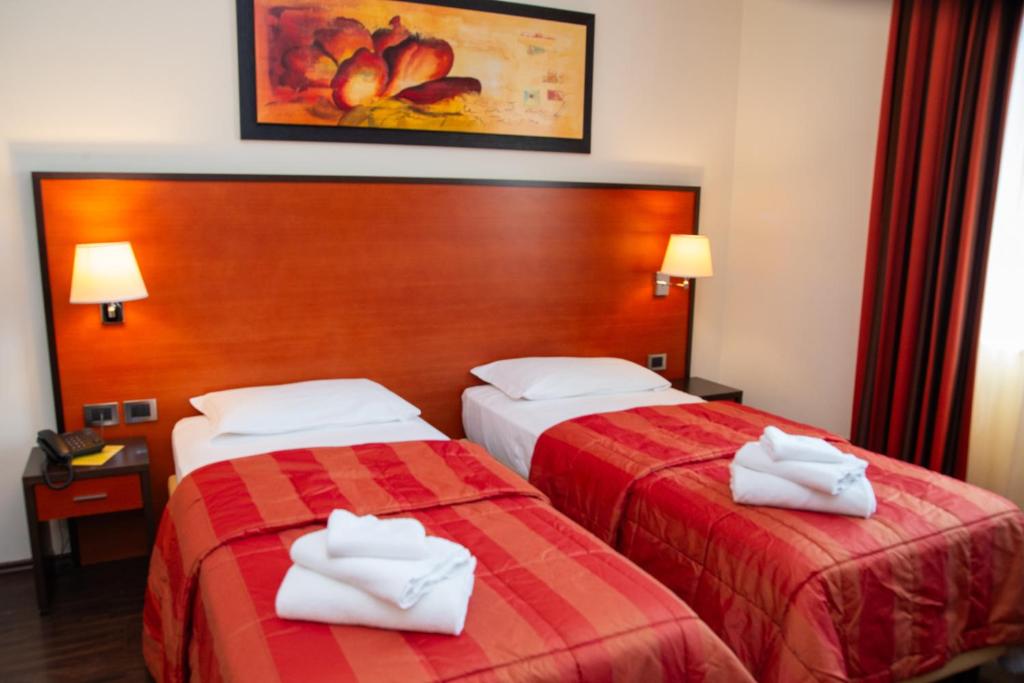 deux lits dans une chambre d'hôtel avec des serviettes dessus dans l'établissement Gullo Hotel, à Curinga
