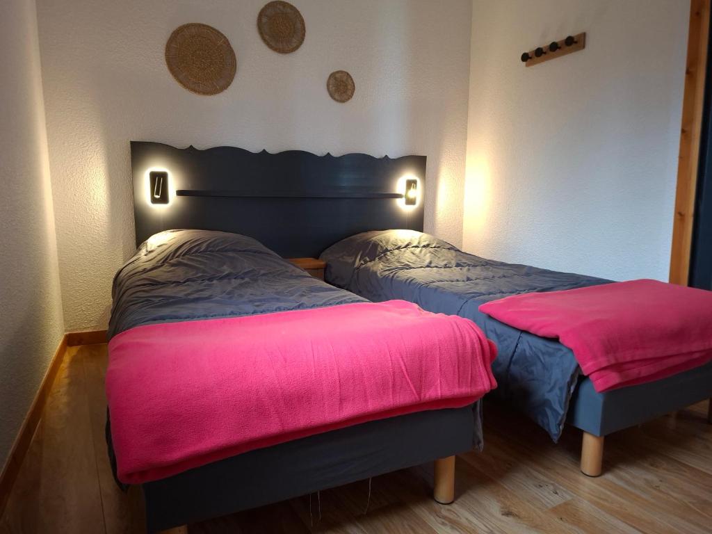 - 2 lits dans une chambre rose et bleue dans l'établissement Chamrousse 1700 - Les Villages du Bachat - Silènes C11 - Classé 3 étoiles, à Chamrousse