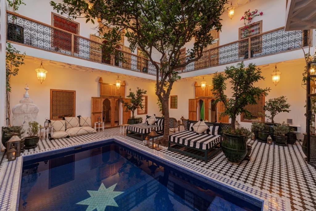 une cour avec piscine meublée et arborée dans l'établissement Riad Botanica, à Marrakech