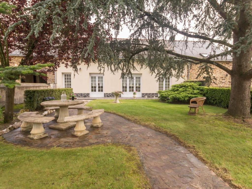 une table de pique-nique et un banc devant une maison dans l'établissement Maison familiale avec piscine, grand jardin clos et équipements de loisirs - FR-1-306-898, à Bonnœuvre