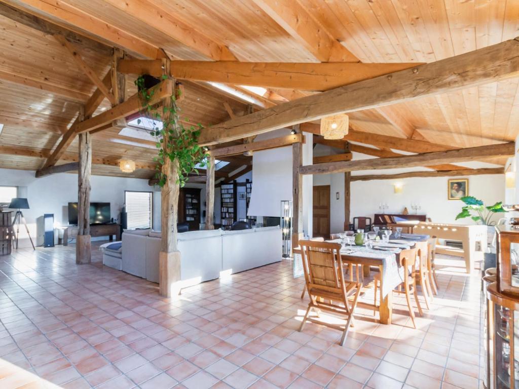 une salle à manger et une cuisine avec une table et des chaises dans l'établissement Gîte familial spacieux avec piscine naturelle, proche Nantes - FR-1-306-1218, à La Limouzinière