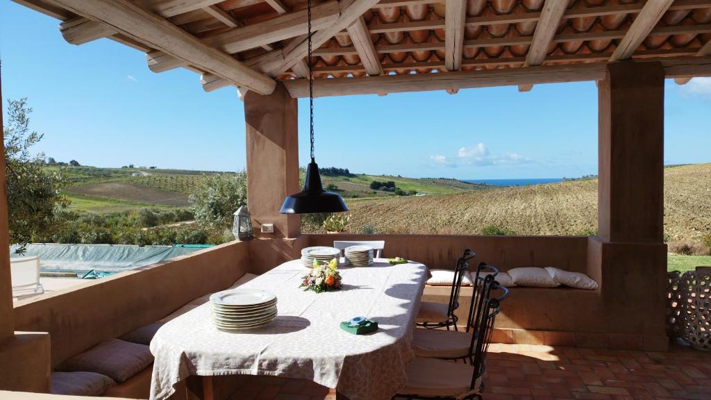 - une table sur une terrasse avec vue sur l'océan dans l'établissement Casa Chardonnay, à Menfi