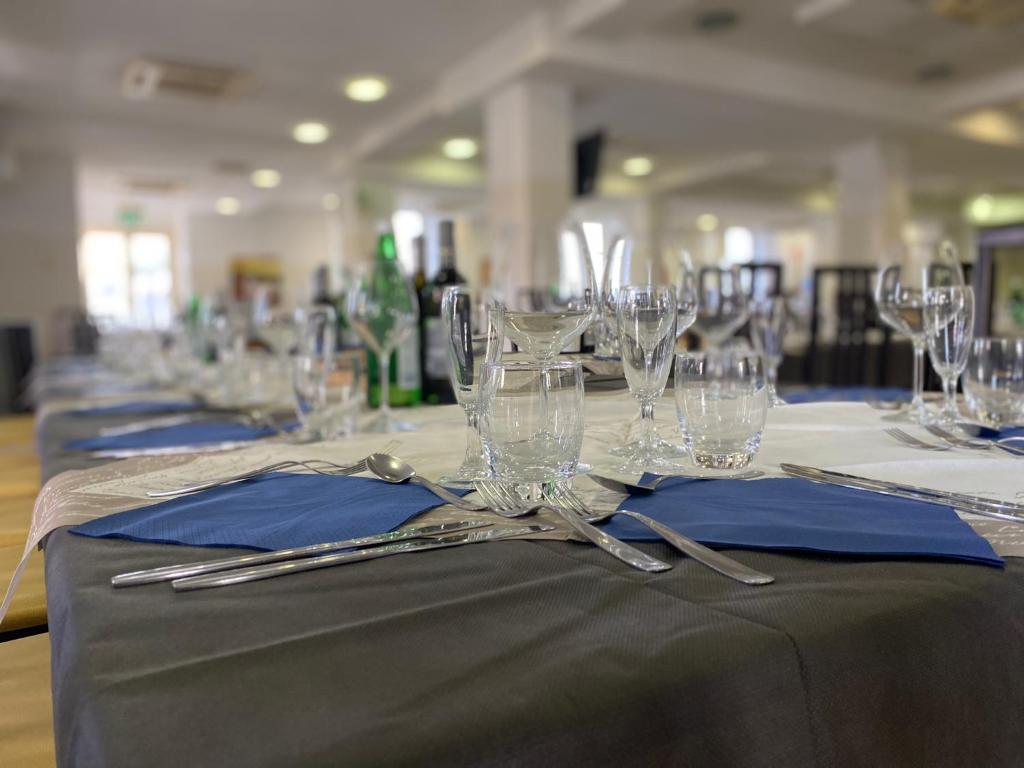 un ensemble de tables avec des verres et des serviettes dessus dans l'établissement Sacro Cuore Hotel, à Marina di Massa