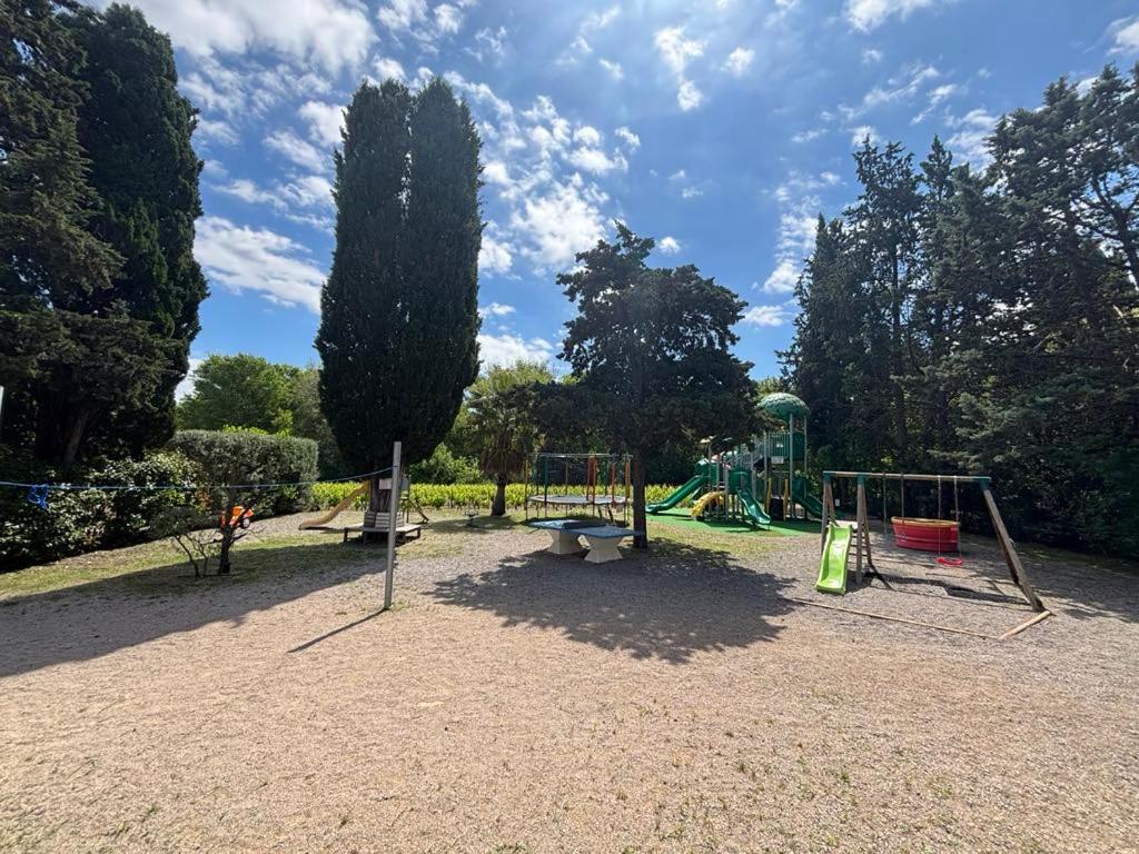 un parc avec une aire de jeux avec un banc et des balançoires dans l'établissement La Vallée De Taradeau, à Taradeau