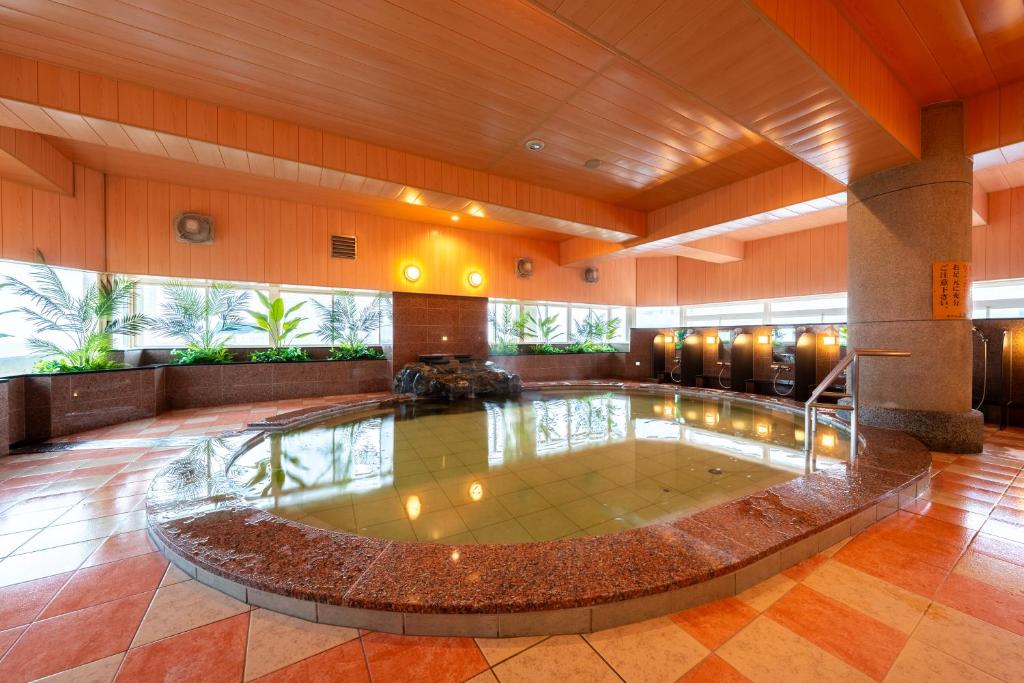 une grande piscine au milieu d'un bâtiment dans l'établissement BeppuOnsen Hotel Sansenkaku, à Beppu