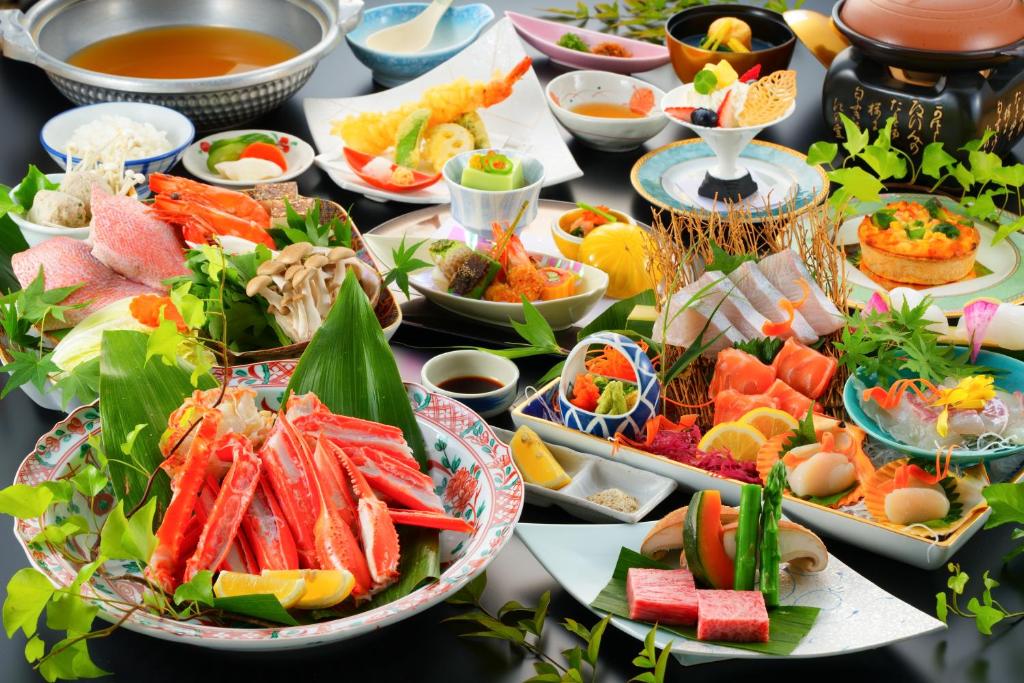 une table avec de nombreuses assiettes de nourriture dessus dans l'établissement BeppuOnsen Hotel Sansenkaku, à Beppu