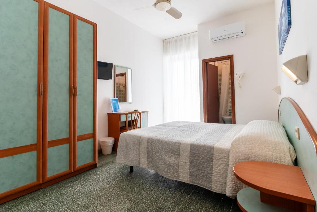 - une chambre avec un lit, une table et une table dans l'établissement Hotel Mara, à Rimini