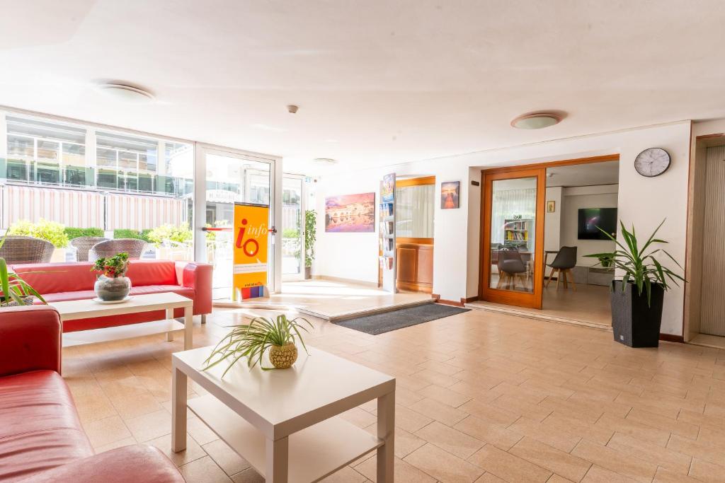 un salon avec un canapé rouge et une table dans l'établissement Hotel Ischia, à Rimini