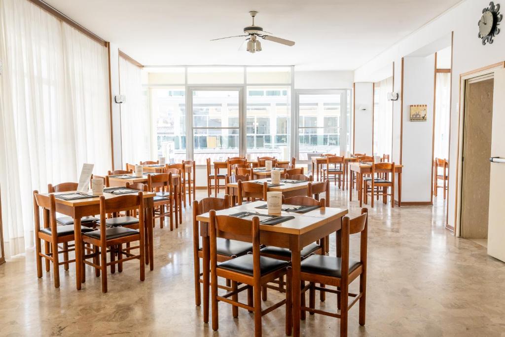 une salle à manger avec des tables et des chaises en bois dans l'établissement Hotel Ischia, à Rimini