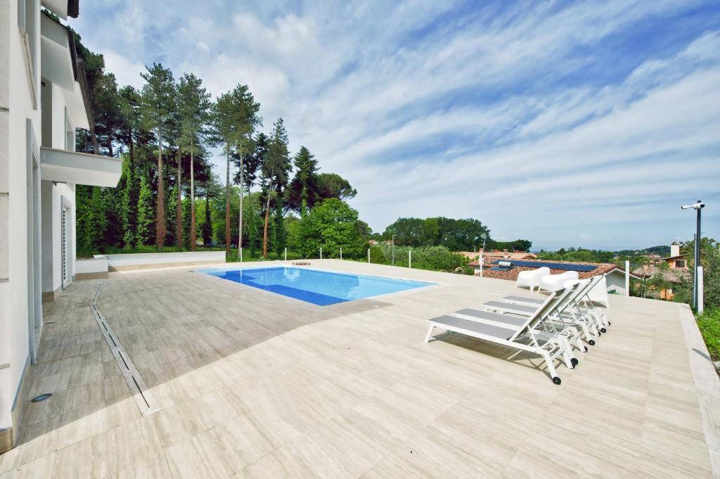 une maison avec une piscine et des chaises longues dans l'établissement Villa dei Gelsomini, à Rocca di Papa