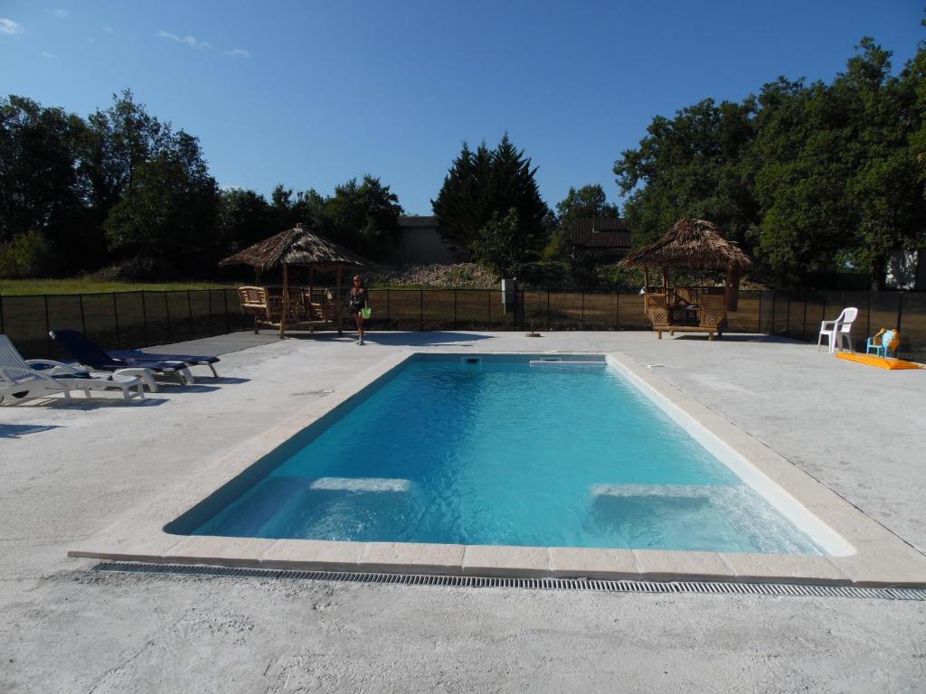 - une piscine dans une cour avec des chaises et une clôture dans l'établissement CAMPING LES PAILLOTES, à Payrac