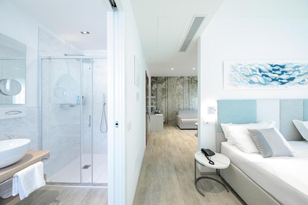 une salle de bain blanche avec lavabo et douche dans l'établissement Hotel Bristol, à Lido di Jesolo