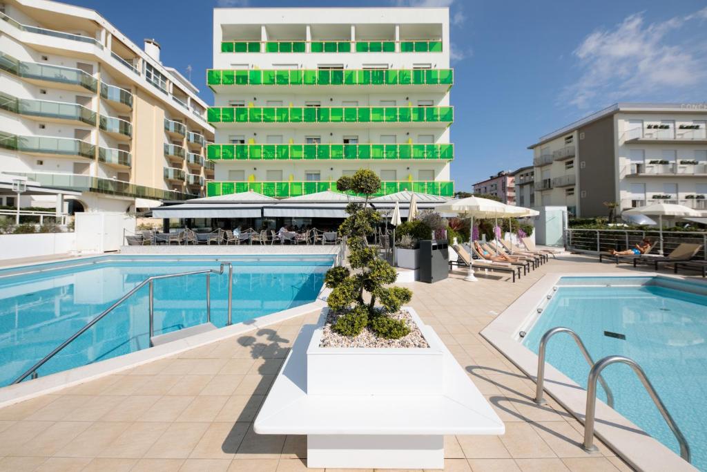 une piscine avec un bâtiment en arrière-plan dans l'établissement Hotel Bristol, à Lido di Jesolo