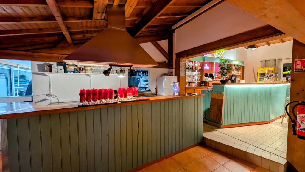 un restaurant avec un comptoir avec des ustensiles rouges dans l'établissement Mobilhome cosy Aulywan, à La Boissière-de-Montaigu