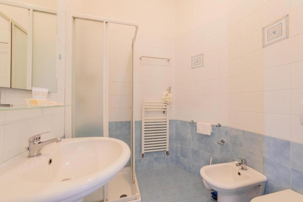 une salle de bain blanche avec un lavabo et des toilettes dans l'établissement Hotel La Perla, à Cupra Marittima