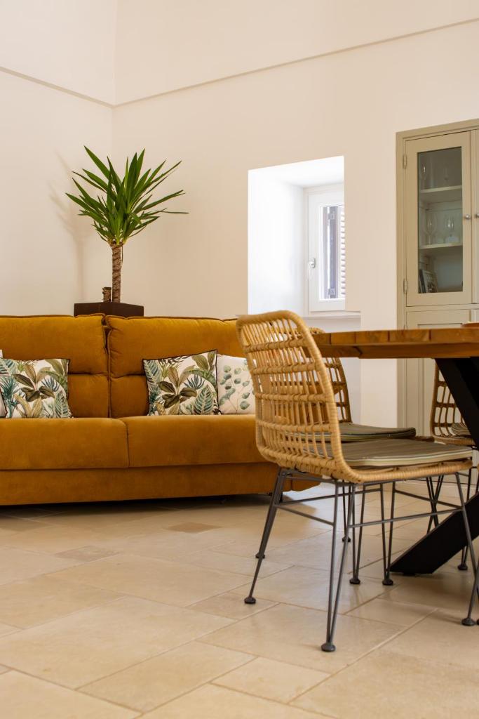 - un canapé jaune dans le salon avec une table dans l'établissement Trullo Pugliarmonia, à Fasano