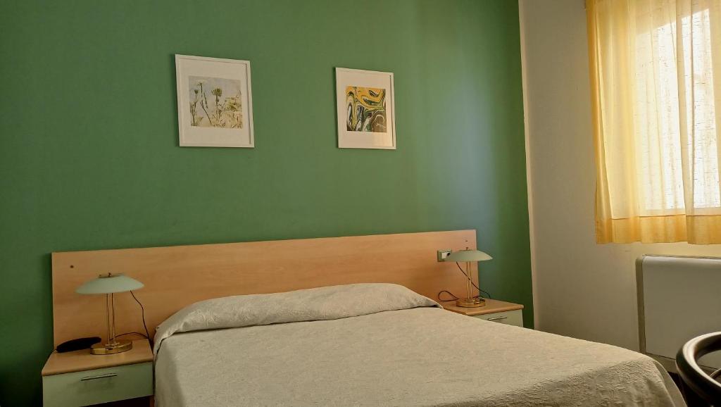 - une chambre avec des murs verts et un lit avec deux lampes dans l'établissement Hotel Ariston Imperial, à Porto Garibaldi
