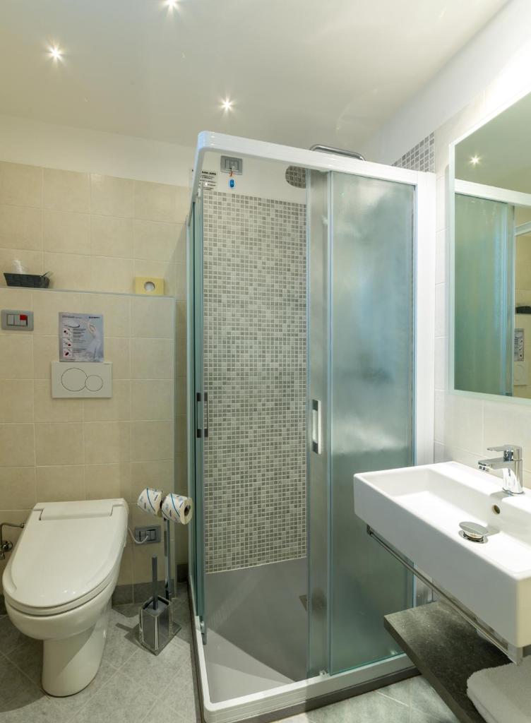 une salle de bain avec une douche, des toilettes et un lavabo dans l'établissement Hotel Residence Mara, à Lido di Jesolo