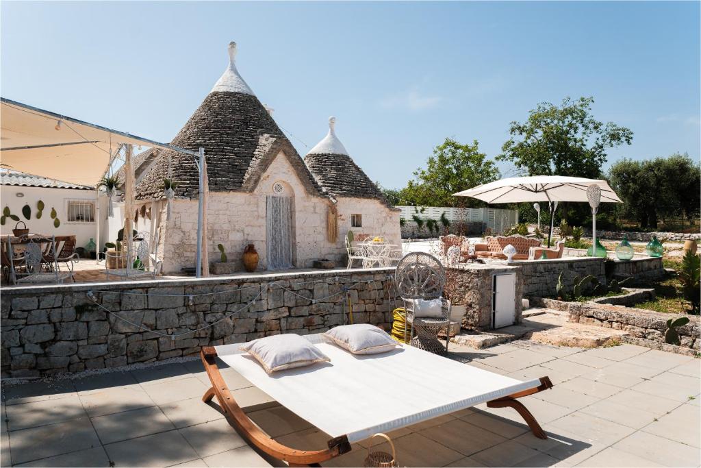 - un lit sur une terrasse avec un mur en pierre dans l'établissement Trulli di Mamma Marì by STHEY, à Castellana Grotte