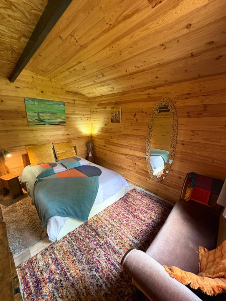une chambre avec deux lits dans une cabane en rondins dans l'établissement Chalet Cricri Domaine de la Mamounette, à Champclause