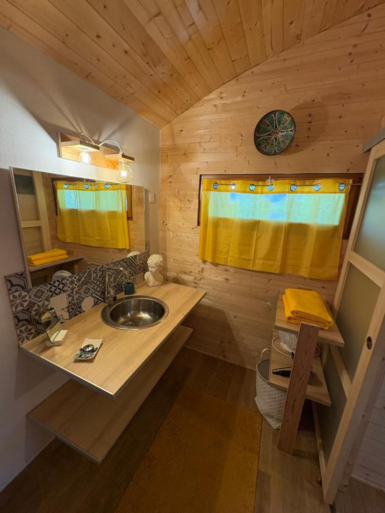 - une salle de bains pourvue d'un lavabo dans une cabine en bois dans l'établissement Chalet grenouille Domaine de la Mamounette, à Champclause