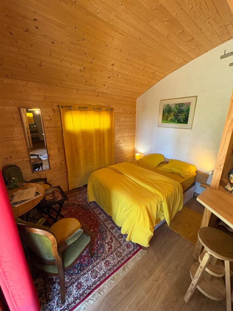 une chambre avec un lit dans une pièce en bois dans l'établissement Chalet grenouille Domaine de la Mamounette, à Champclause