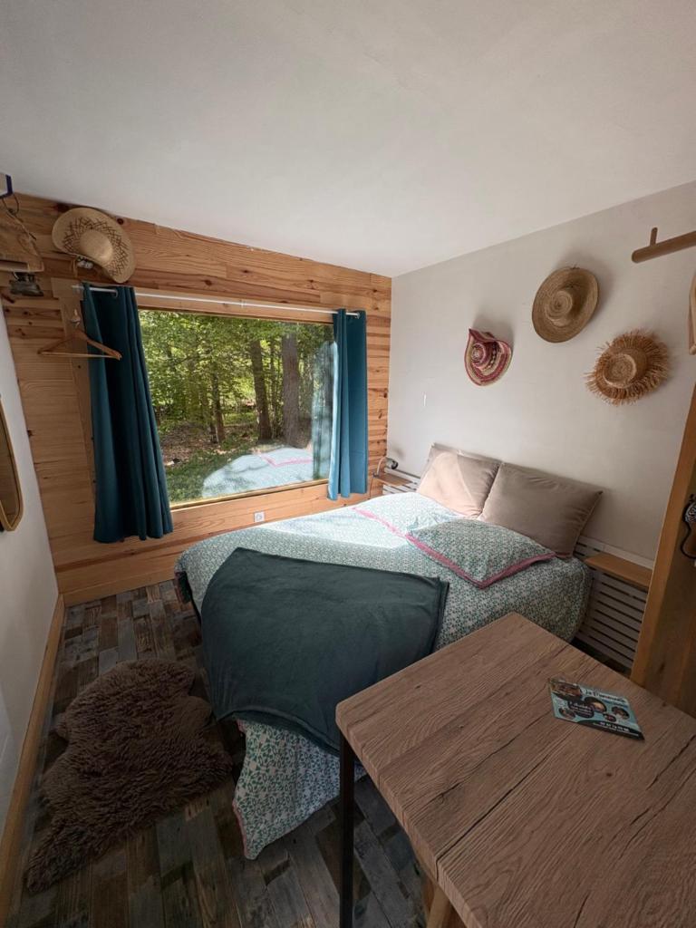 une petite chambre avec un lit et une table dans l'établissement Chalet Hibou 1 couchage en 140 Domaine de la Mamounette, à Champclause