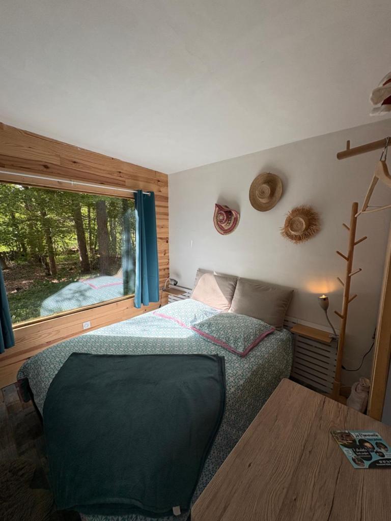une chambre avec un lit et une grande fenêtre dans l'établissement Chalet Hibou 1 couchage en 140 Domaine de la Mamounette, à Champclause