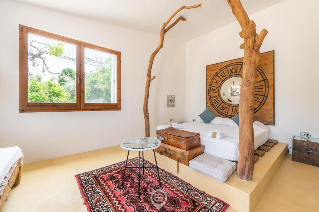 - une chambre avec un lit et un arbre dans l'établissement Villa Barbagallo, à Porto Columbu - Perdʼe Sali
