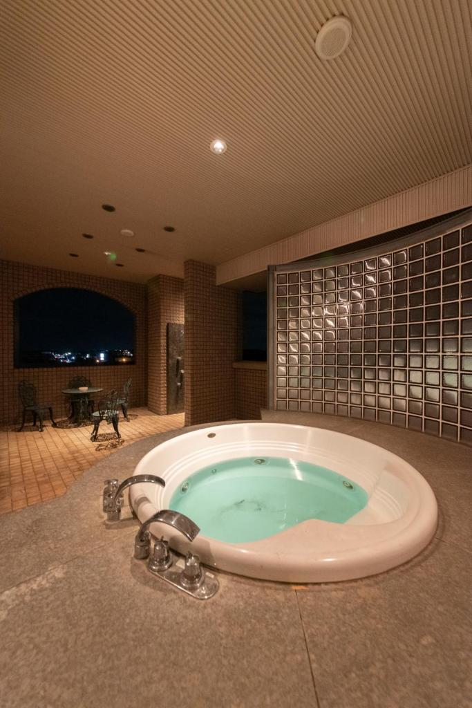 une grande salle de bains avec un bain à remous dans la chambre dans l'établissement ホテルネオワカバ, à Tsuchiura