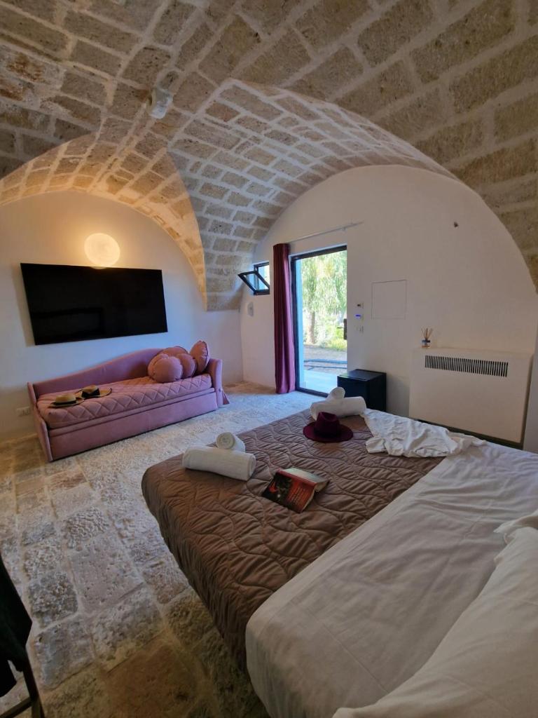 une chambre avec un grand lit et un canapé dans l'établissement Imperial Paradise, à Monopoli