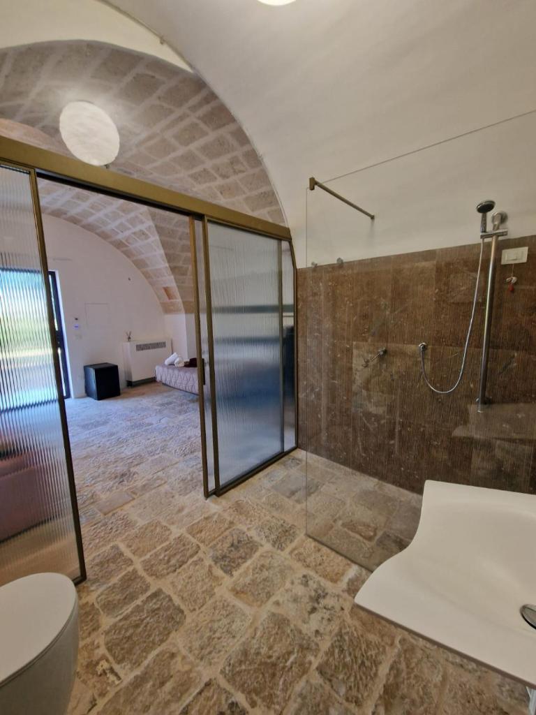 une salle de bain avec une douche en verre et des toilettes dans l'établissement Imperial Paradise, à Monopoli