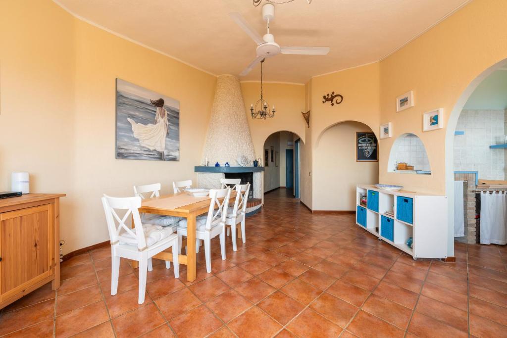 une cuisine et une salle à manger avec une table et des chaises dans l'établissement Villa Mare e Monti, à Sìnnai