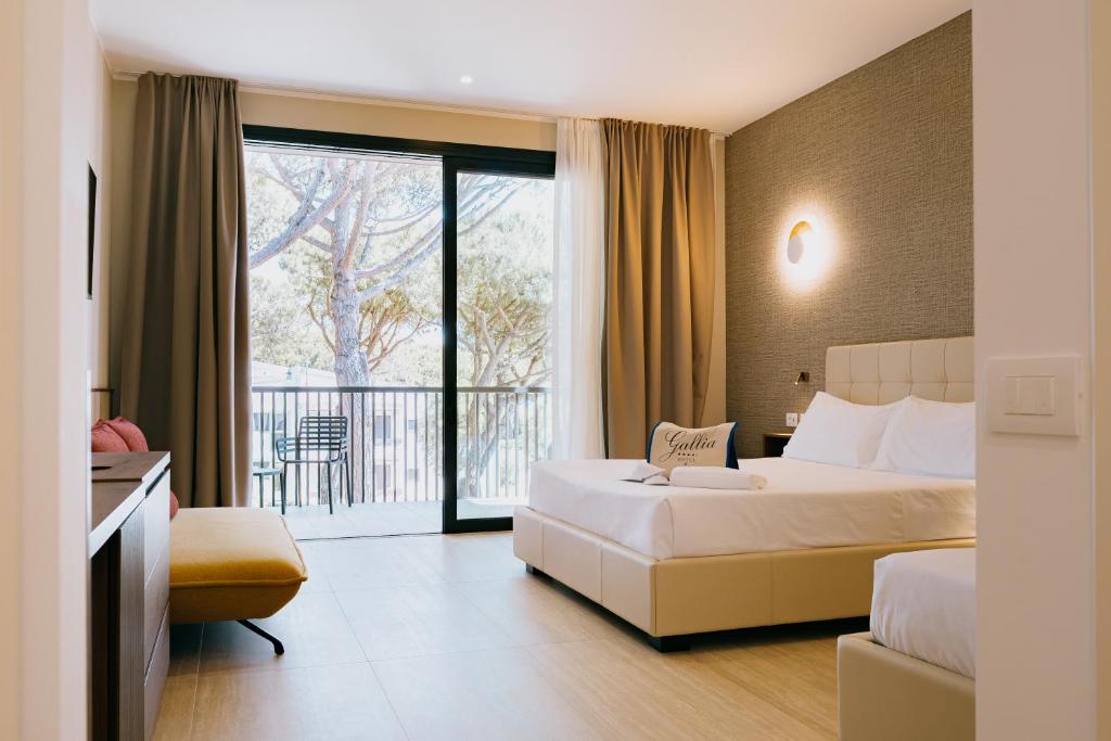 une chambre d'hôtel avec deux lits et un balcon dans l'établissement Hotel Gallia & Resort, à Lido di Jesolo