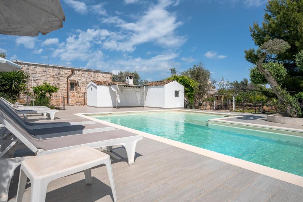une piscine dans une villa avec une maison dans l'établissement Villa Trullo Ulivo with pool, à Carovigno