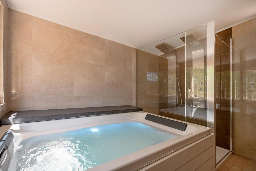 une grande baignoire dans une salle de bain avec douche dans l'établissement Villa Trullo Ulivo with pool, à Carovigno