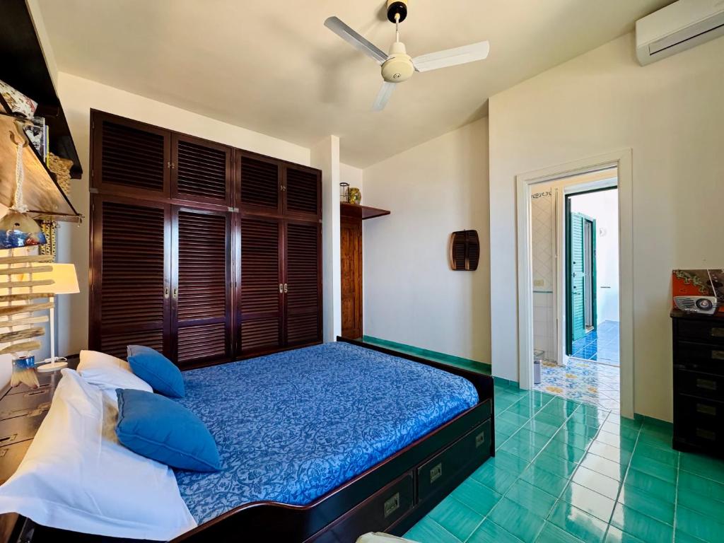 une chambre avec un lit avec des oreillers bleus et une fenêtre dans l'établissement YourHome - Villa Ayala, à Vico Equense 24 autres photos