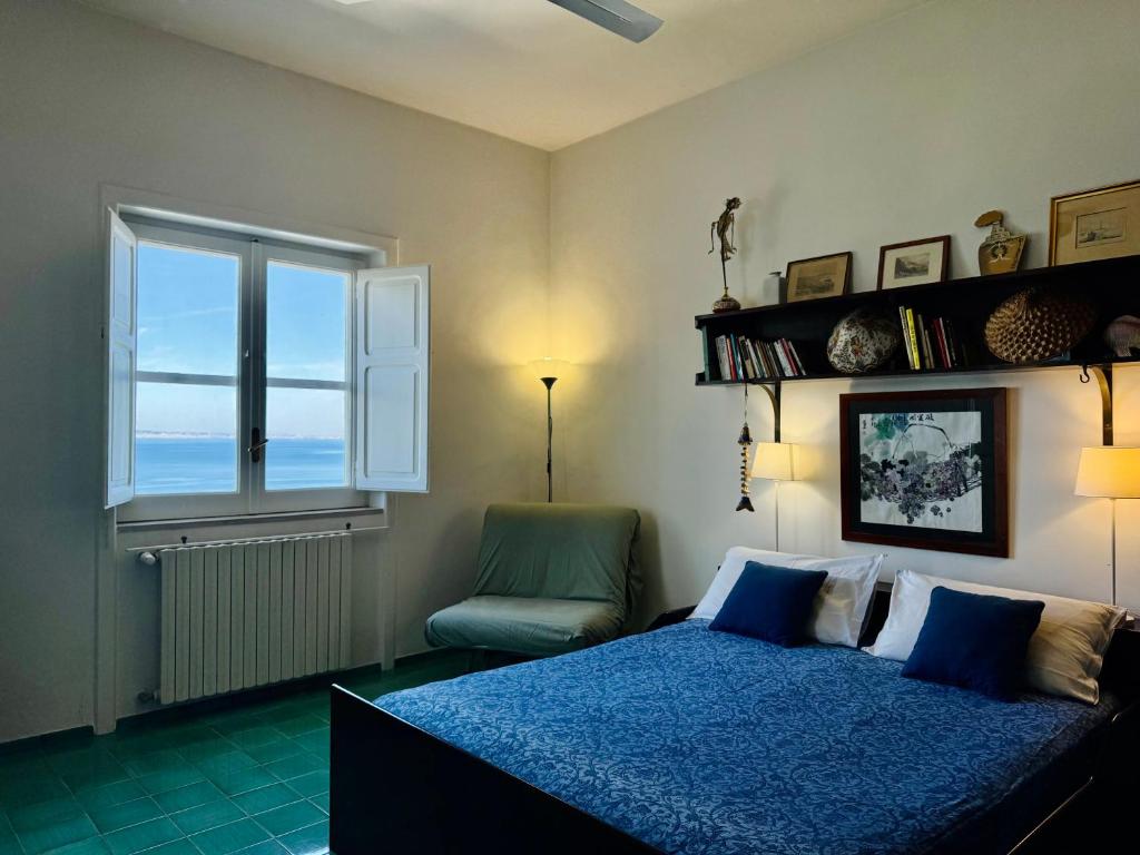 une chambre avec un lit, une fenêtre et une chaise dans l'établissement YourHome - Villa Ayala, à Vico Equense