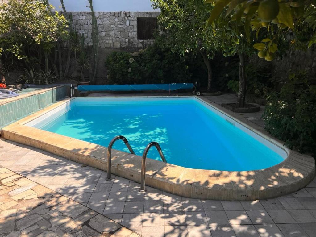 une piscine avec de l'eau bleue dans une cour dans l'établissement YourHome - Villa Ayala, à Vico Equense