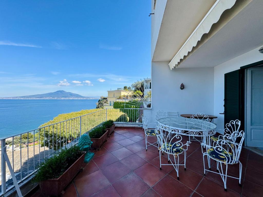 un balcon avec une table et des chaises et l'océan dans l'établissement YourHome - Villa Ayala, à Vico Equense