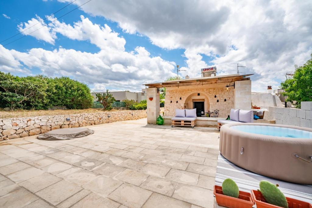 un patio avec un bain à remous et un bâtiment dans l'établissement La Lamia di Rodry by Rentbeat, à Ostuni