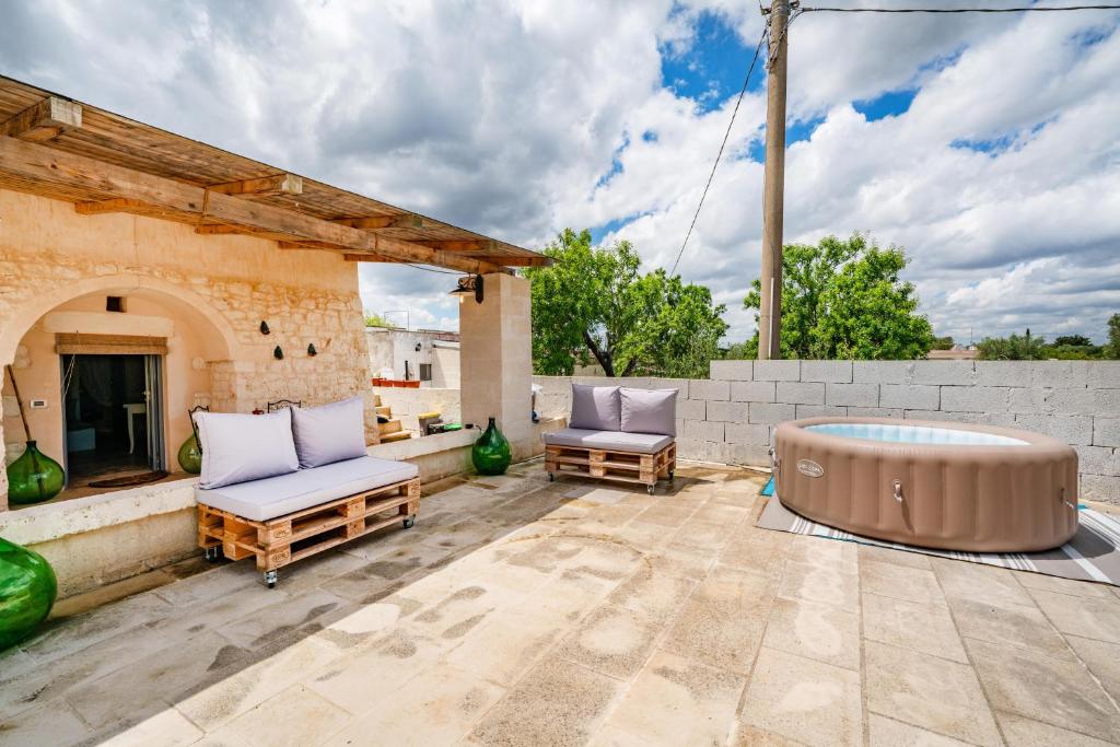d'une terrasse avec un bain à remous et deux chaises. dans l'établissement La Lamia di Rodry by Rentbeat, à Ostuni