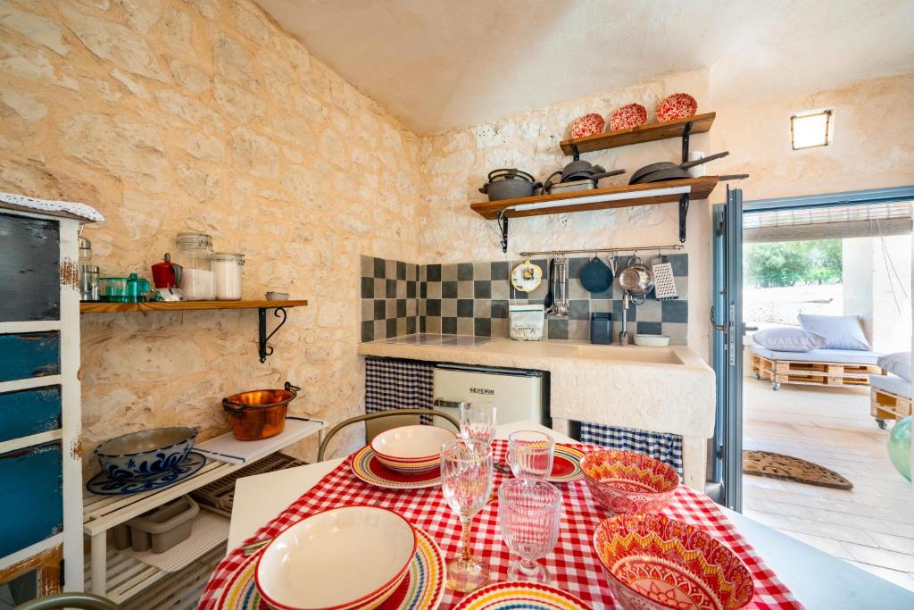 une cuisine avec une table avec des assiettes dessus dans l'établissement La Lamia di Rodry by Rentbeat, à Ostuni