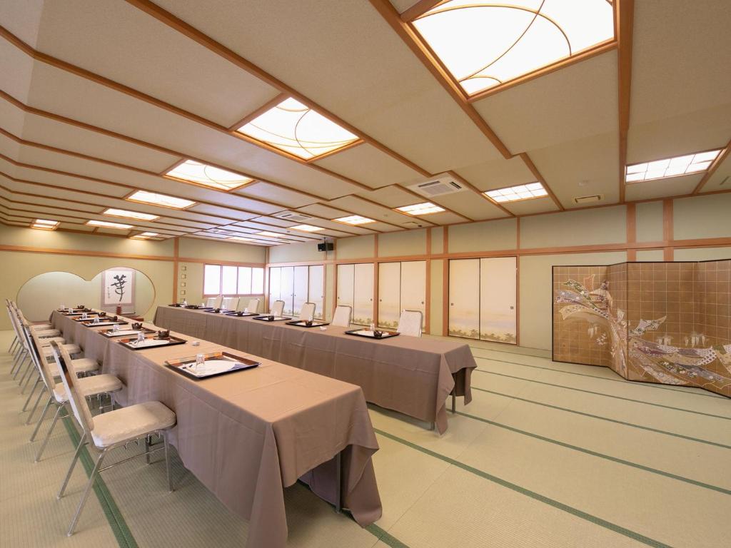 une grande chambre avec des tables et des chaises. dans l'établissement Ryotei Jyusouya, à Sango 37 autres photos