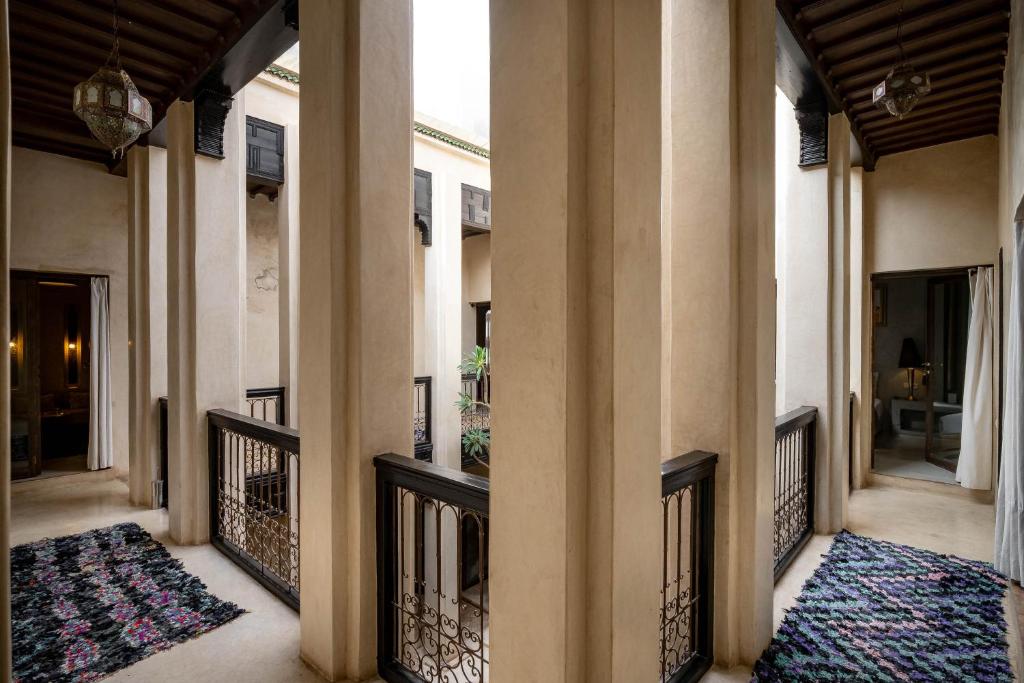 un couloir d'une maison avec des colonnes et des tapis dans l'établissement Riad Vanilla Sma & Spa, à Marrakech