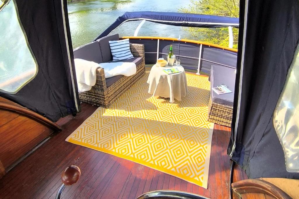 un pont d'un bateau avec une table sur celui-ci dans l'établissement SEALOV Hébergements insolites- linge, ménage et vélos inclus, à Eaucourt-sur-Somme