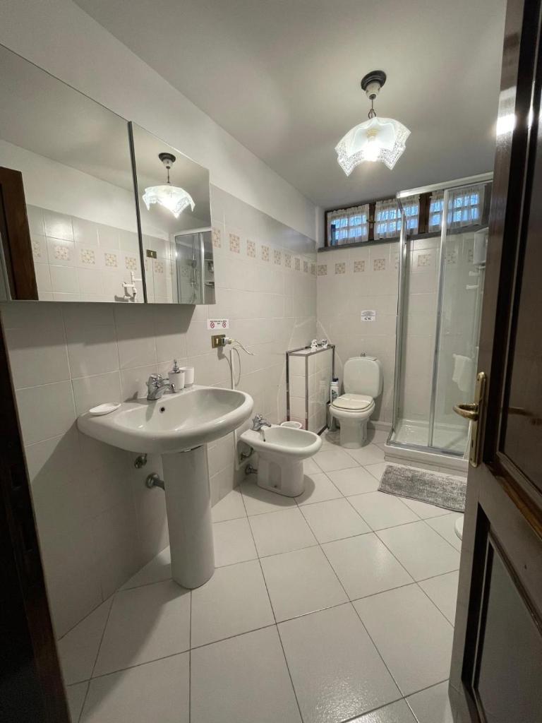une salle de bain blanche avec un lavabo et des toilettes dans l'établissement Villa Ondina Versilia, à Lido di Camaiore